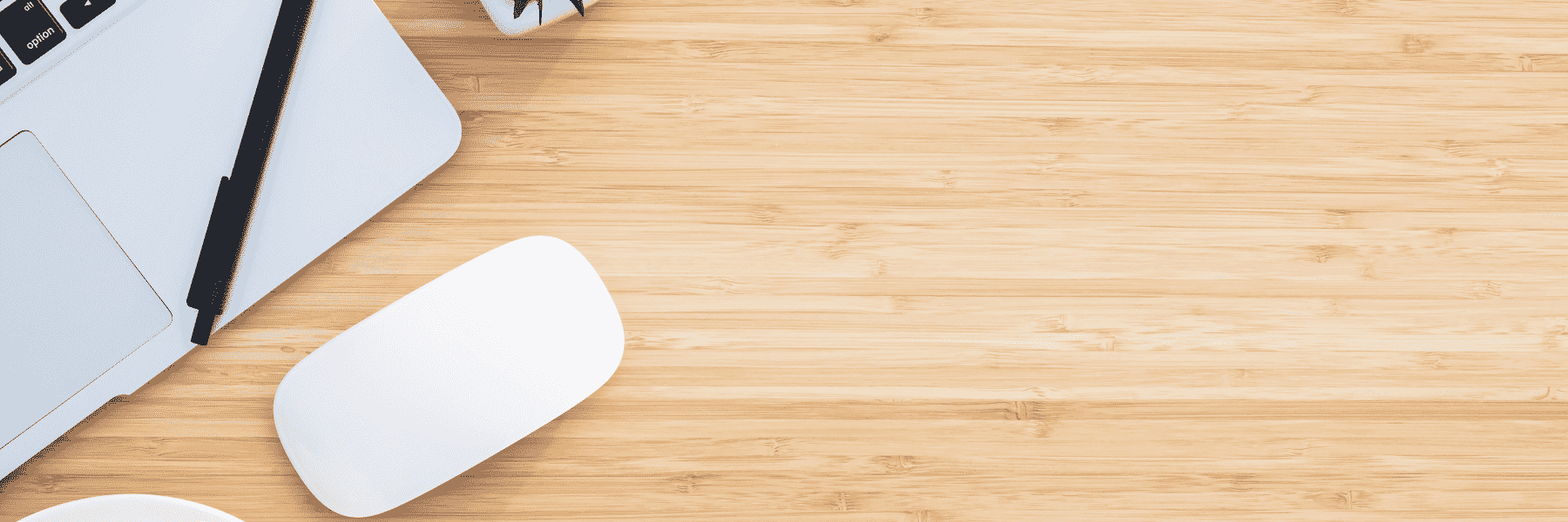 Picture of a desk with a laptop and mouse off to the left