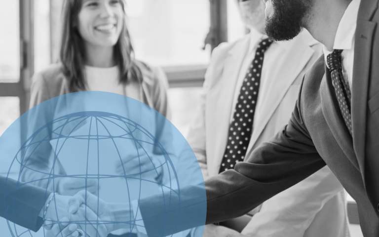 People gather and shake hands around printer.