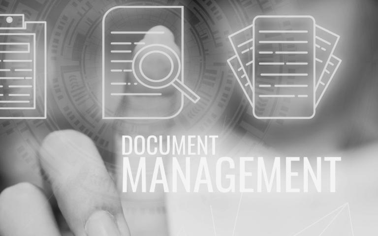 grayscale photo of hand pointing to paper graphic with words document management