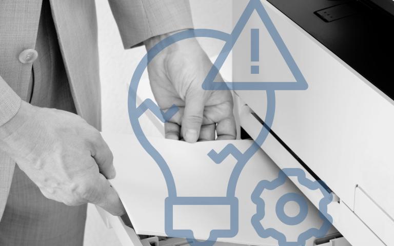 A woman using a printer with a light bulb and warning sign graphic overlay