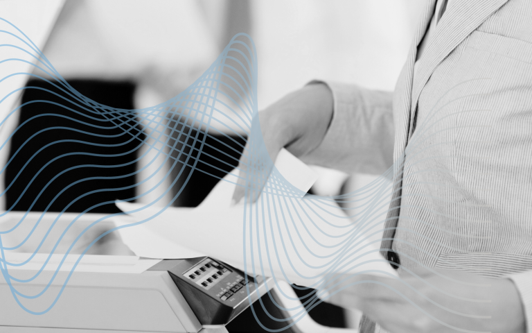 A woman stands by printer.