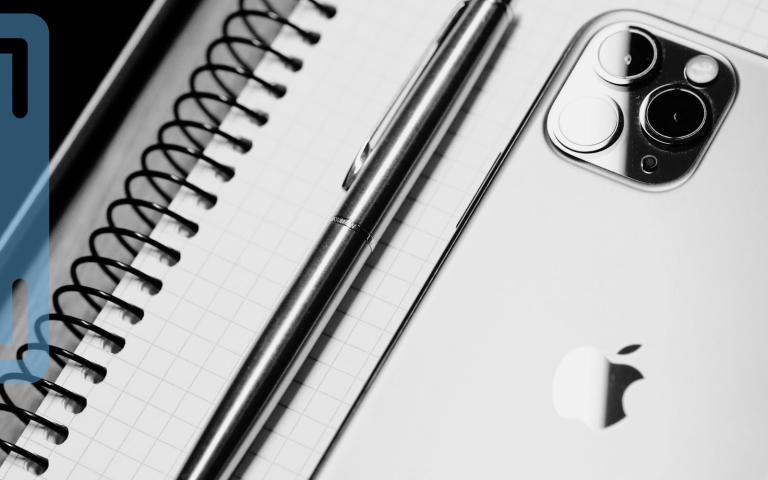 An iPhone on top of a notebook