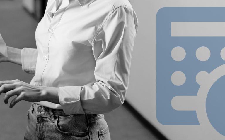 A woman holding a printer page in front of a printer