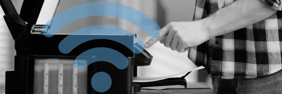 Man's hand pressing a button on a home printer