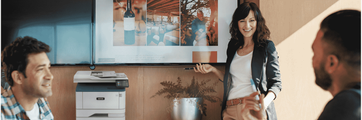 A group of people talking with the Xerox B305 in the background