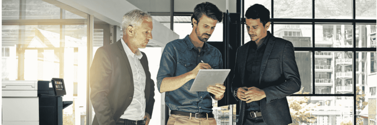 Three people standing near the Xerox VersaLink C605