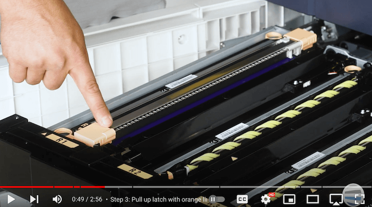 Printer technician points to the corotron assembly on the Xerox PrimeLink C9065