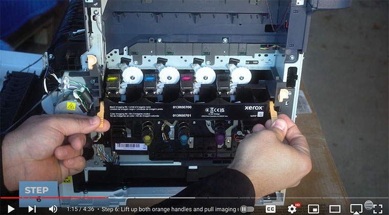 Printer technician lifts both handles on side of imaging unit kit of Xerox VersaLink C410/C415