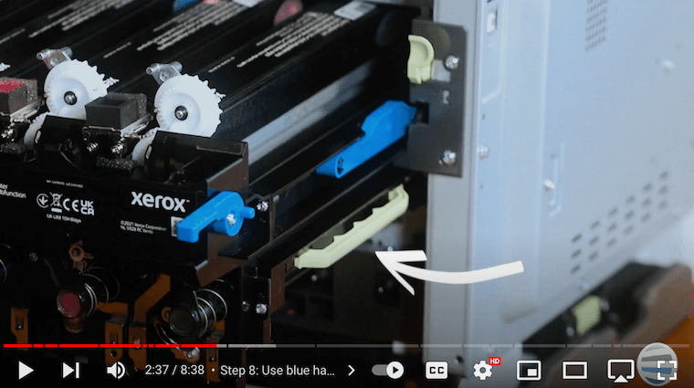 Printer technician points out the green handles of the imaging kit tray of the Xerox C315 printer