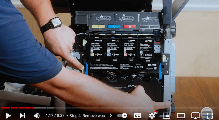 Printer technician pushes green tabs inward of the Xerox C315 printer