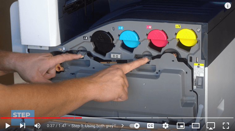 Printer technician uses grey latches to pull out the waste cartridge on the Xerox VersaLink C7030