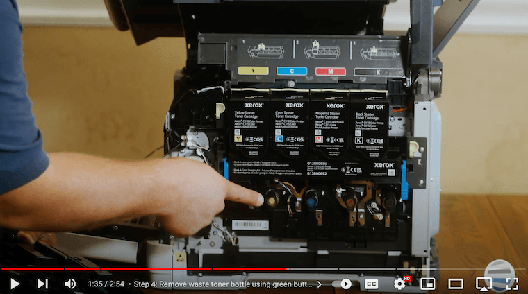 A printer technician inserts new waste toner bottle on the Xerox C315
