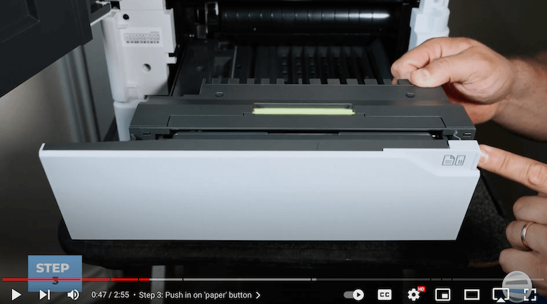 A printer technician pushes the 'paper' button of the VersaLink B625 to lower the bypass tray