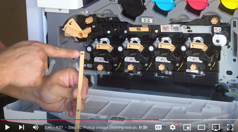 Printer technician points to grey felt on cleaning tool on the Xerox VersaLink C7020/C7025/C7030