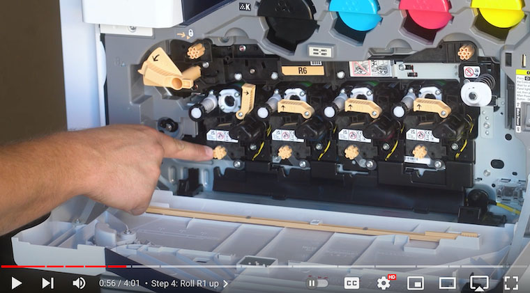 Printer technician unscrews orange screw on Xerox VersaLink C7020/C7025/C7030